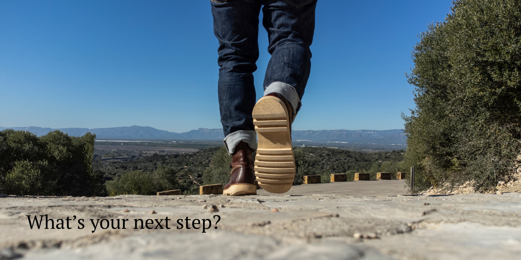Man walking down a gravel path in a natural environment