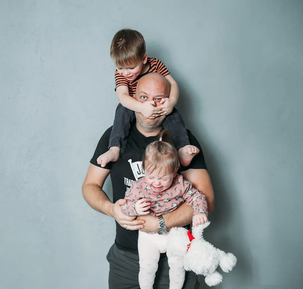 Dad with children crawling all over him.