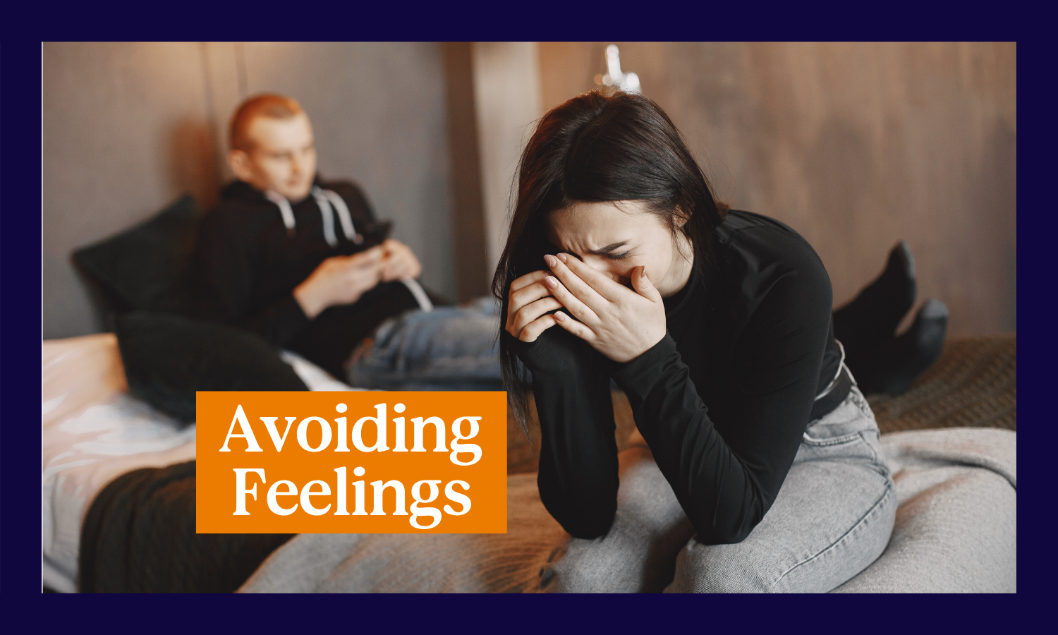 Woman crying on a bed with man on his phone in background with the title, "Avoiding Feelings"