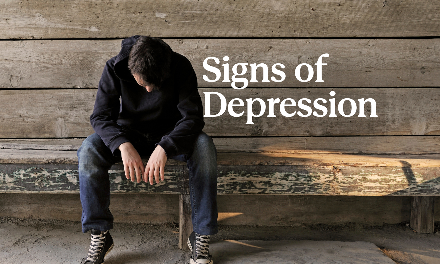 Man sitting alone on a bench with the title, "Signs of Depression"